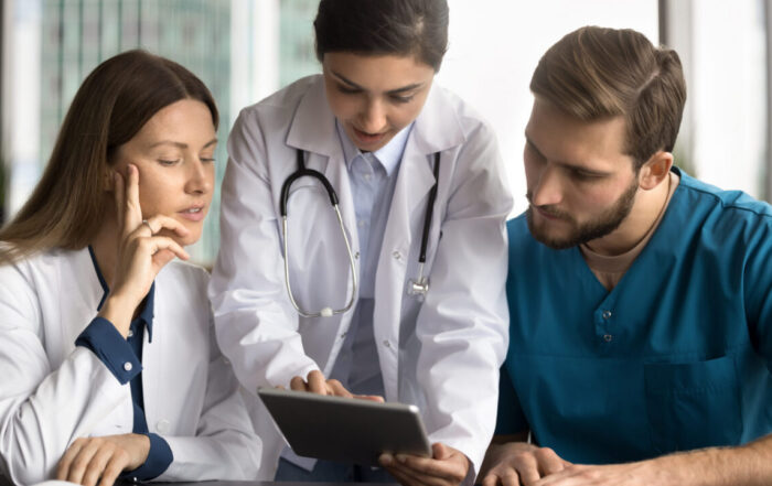 A gastroenterology team reviews patient records on a tablet in a modern clinic