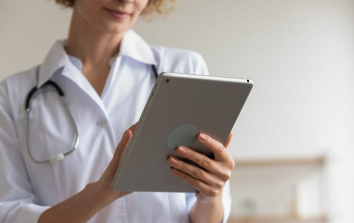 A physician reviews medical research on a tablet in a modern clinical office setting
