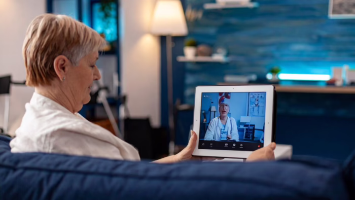 Person using a tablet for a virtual care visit at home.